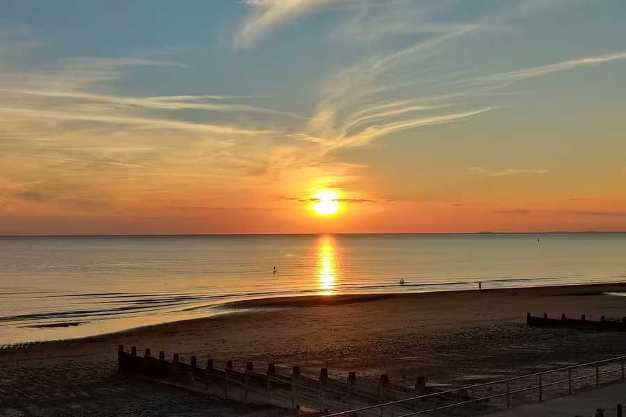 Golden sunset over Tywyn beach and Cardigan Bay from the promenade, Mid-Wales