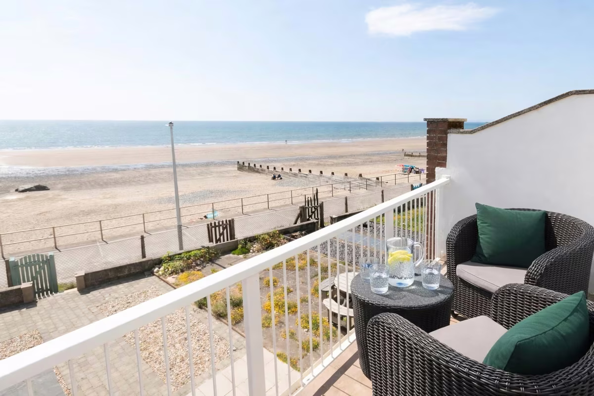 Four Degrees West – balcony with rattan seating overlooking Tywyn beach and Cardigan Bay