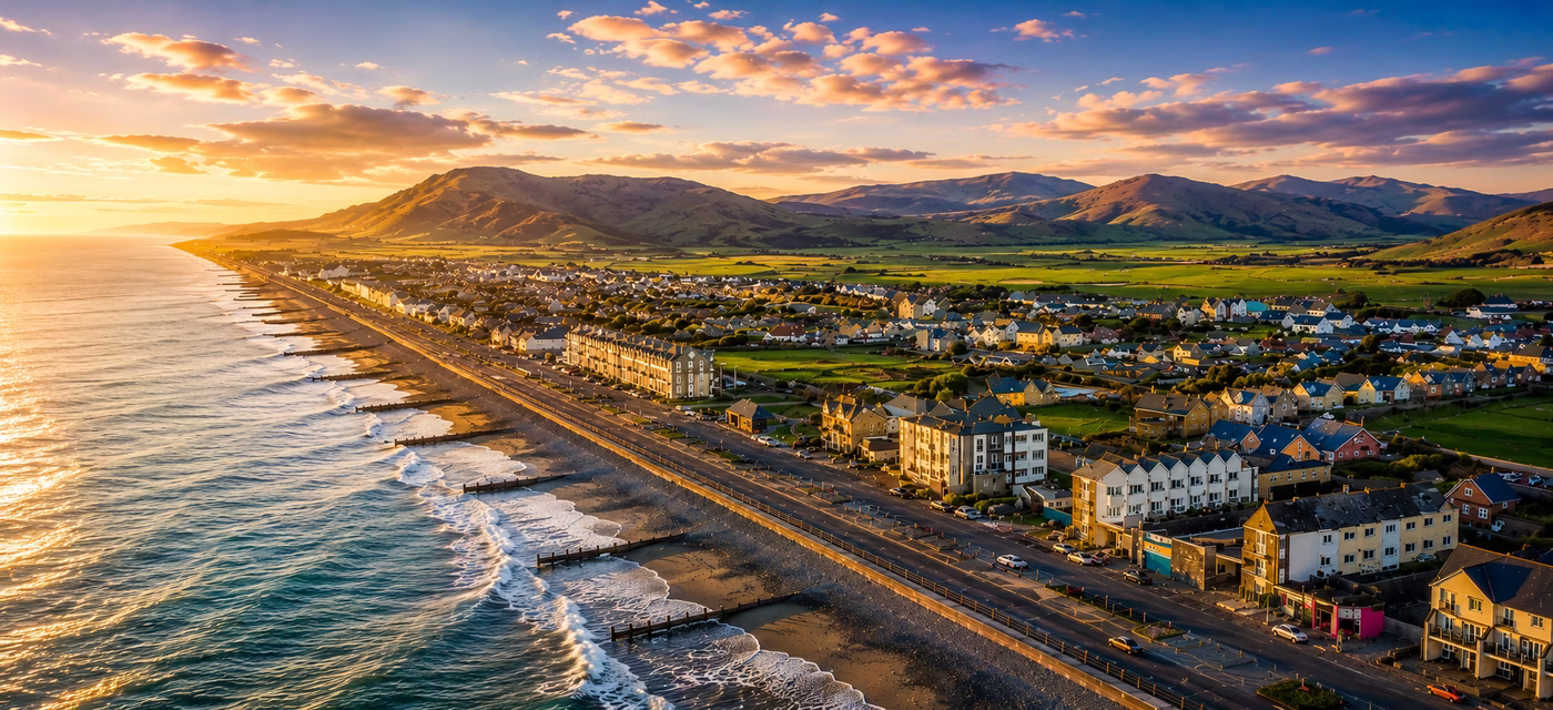 Aerial drone view of Tywyn beach, promenade and mountains at sunset